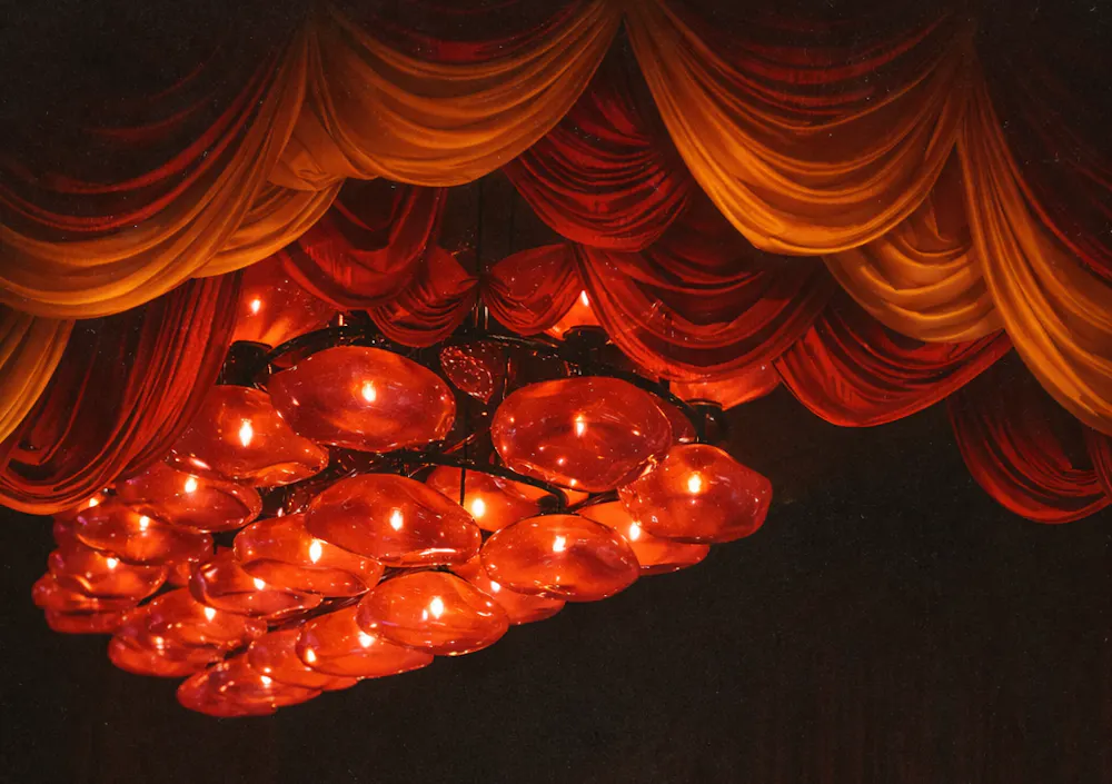 Draped ceiling and glowing red lighting installation inside Wax Rabbit speakeasy, a cool Las Vegas vinyl bar known for immersive ambiance and live DJs.