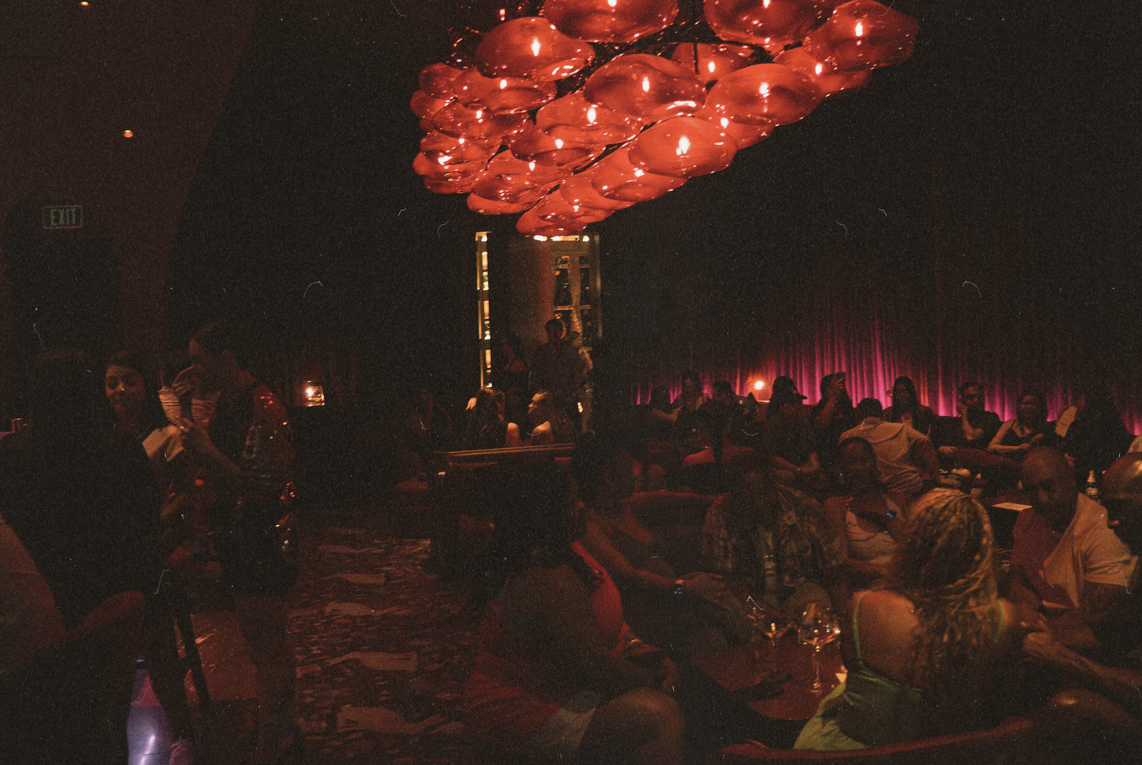 Guests enjoying cocktails inside Wax Rabbit, a hidden Las Vegas speakeasy featuring velvet interiors, vinyl DJs, and a sophisticated cocktail lounge atmosphere.