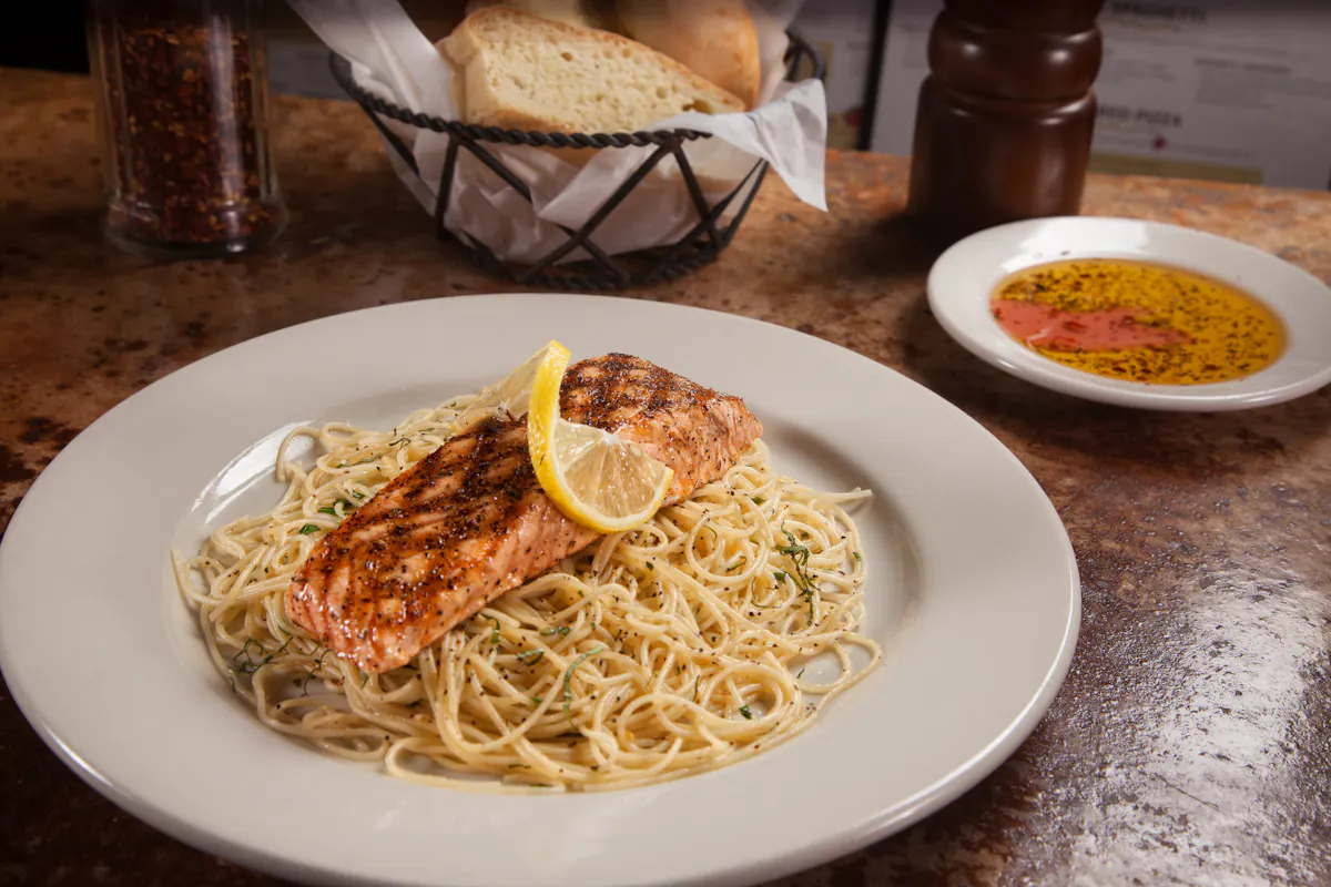 a white plate topped with spaghettis and grilled chicken breast