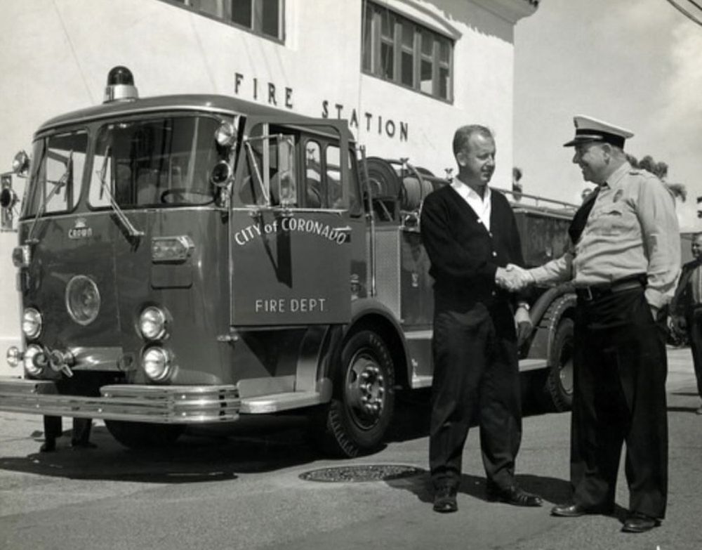 a man shaking hands with a fire truck