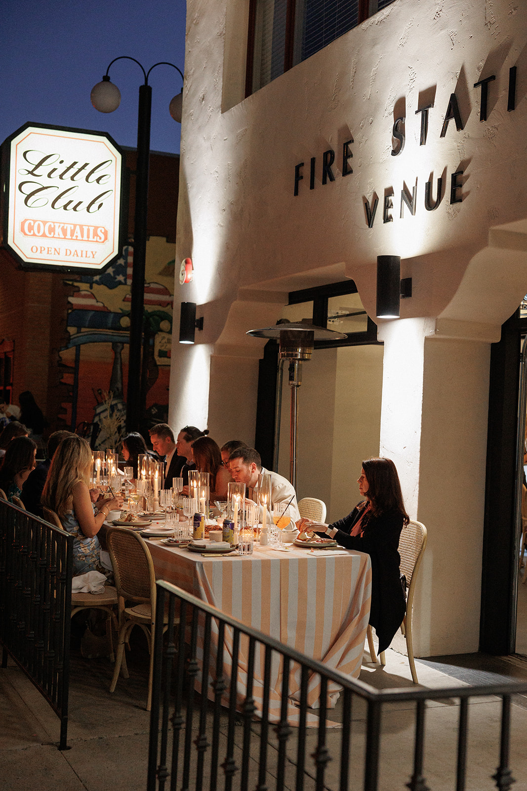 a groupcode  delete of people sitting at a table outside a restaurant