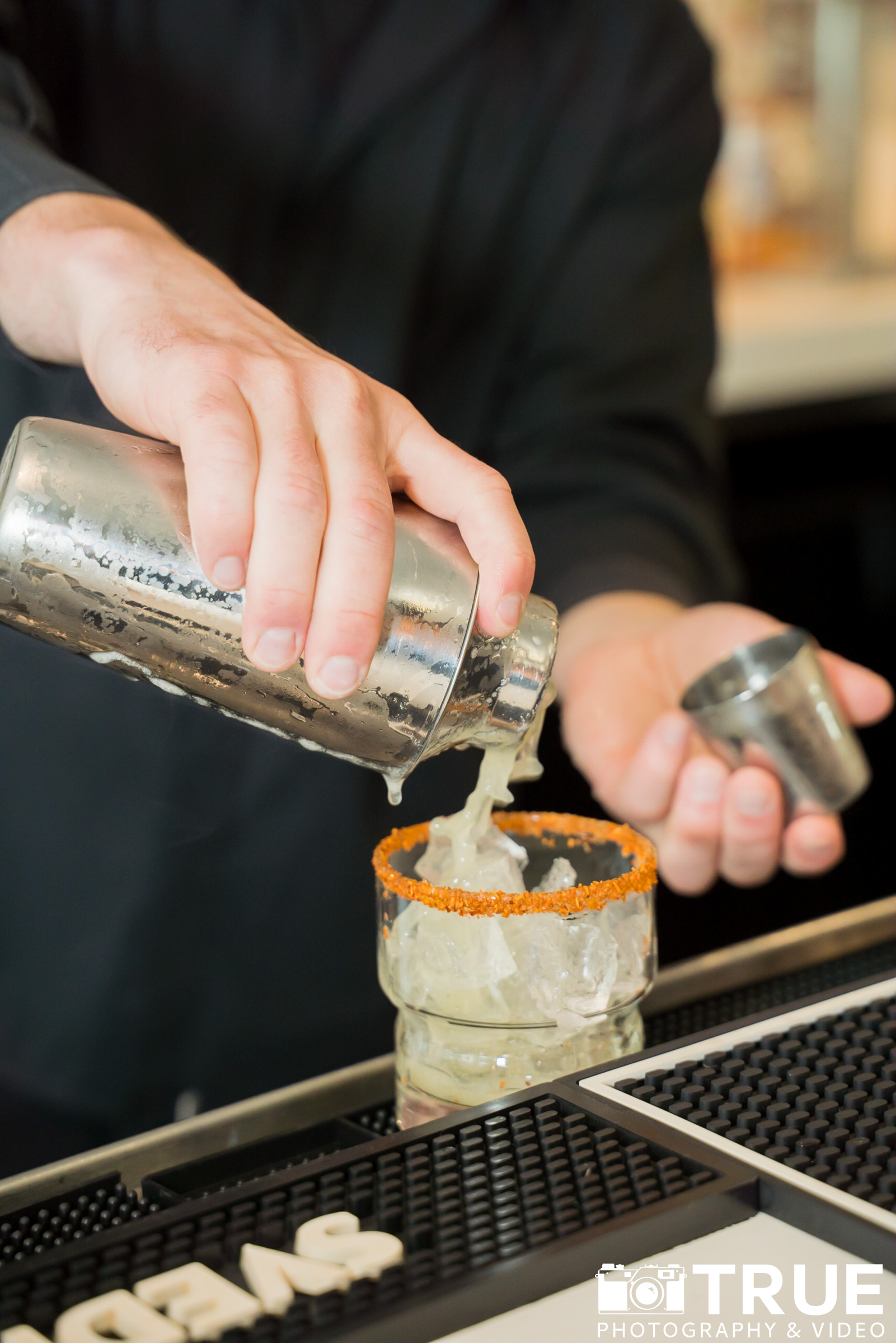 a person pouring a drink into a glass