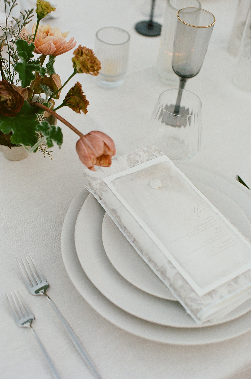 a table setting with a flower and a napkin on top