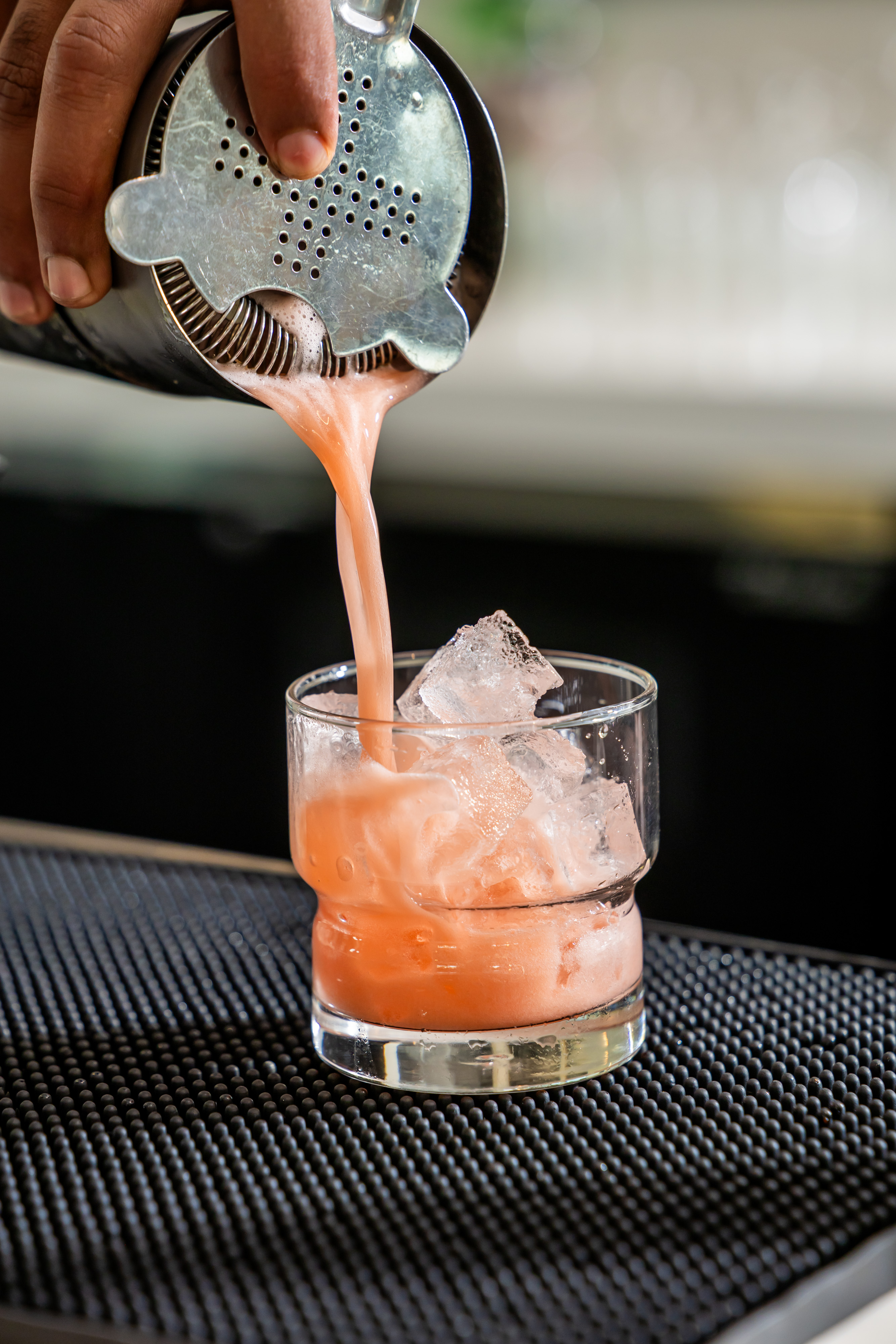 a person pouring a drink into a glass