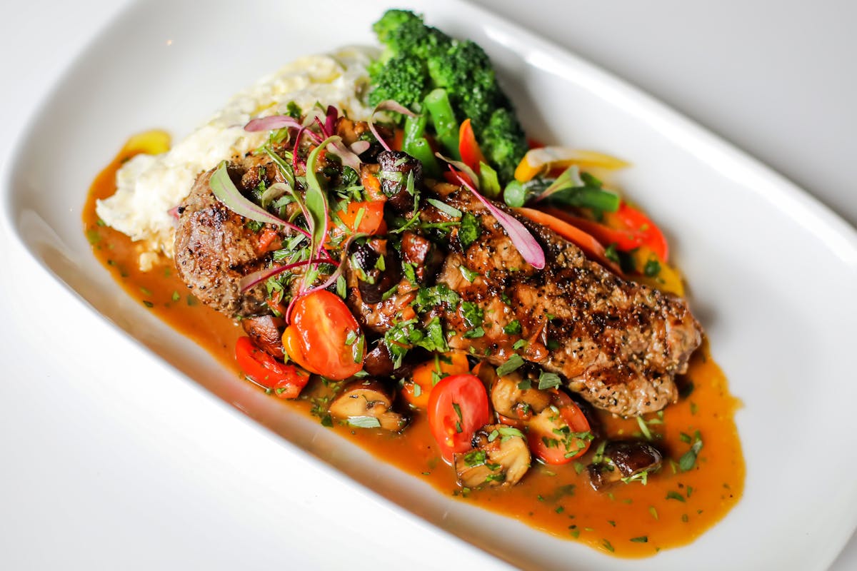 a grilled meat with mashed potatoes and vegetables