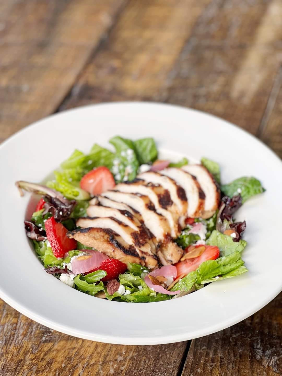 a salad with grilled meat on top