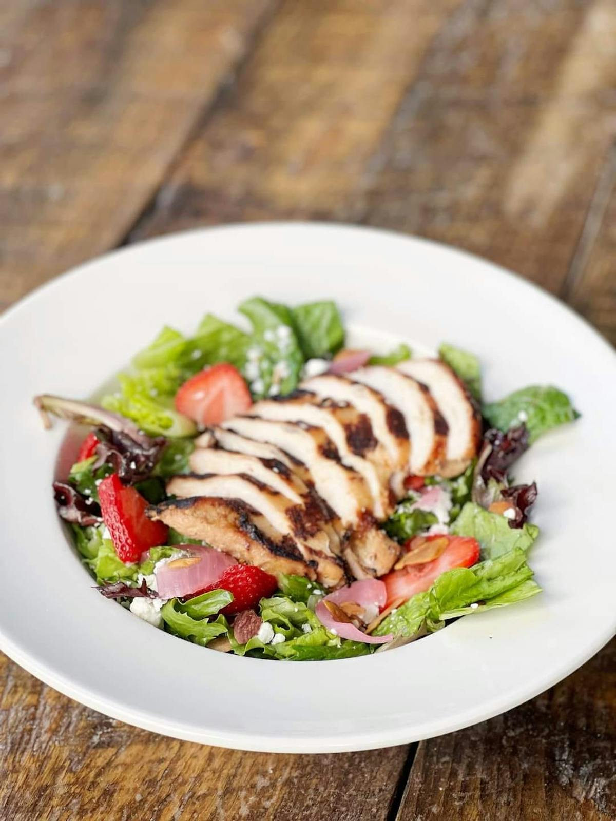 a salad with grilled meat on top