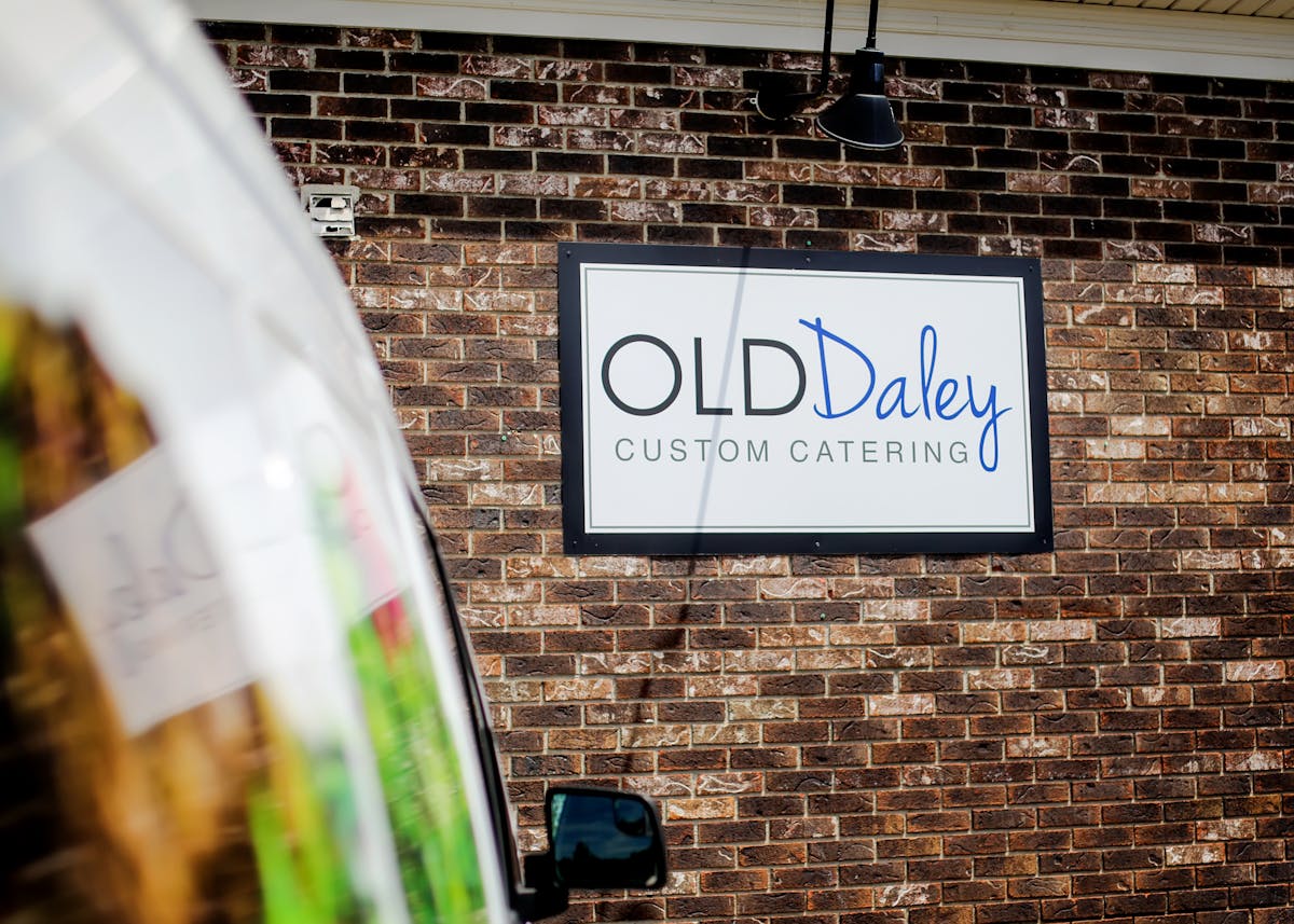 an old Daley sign on a brick wall