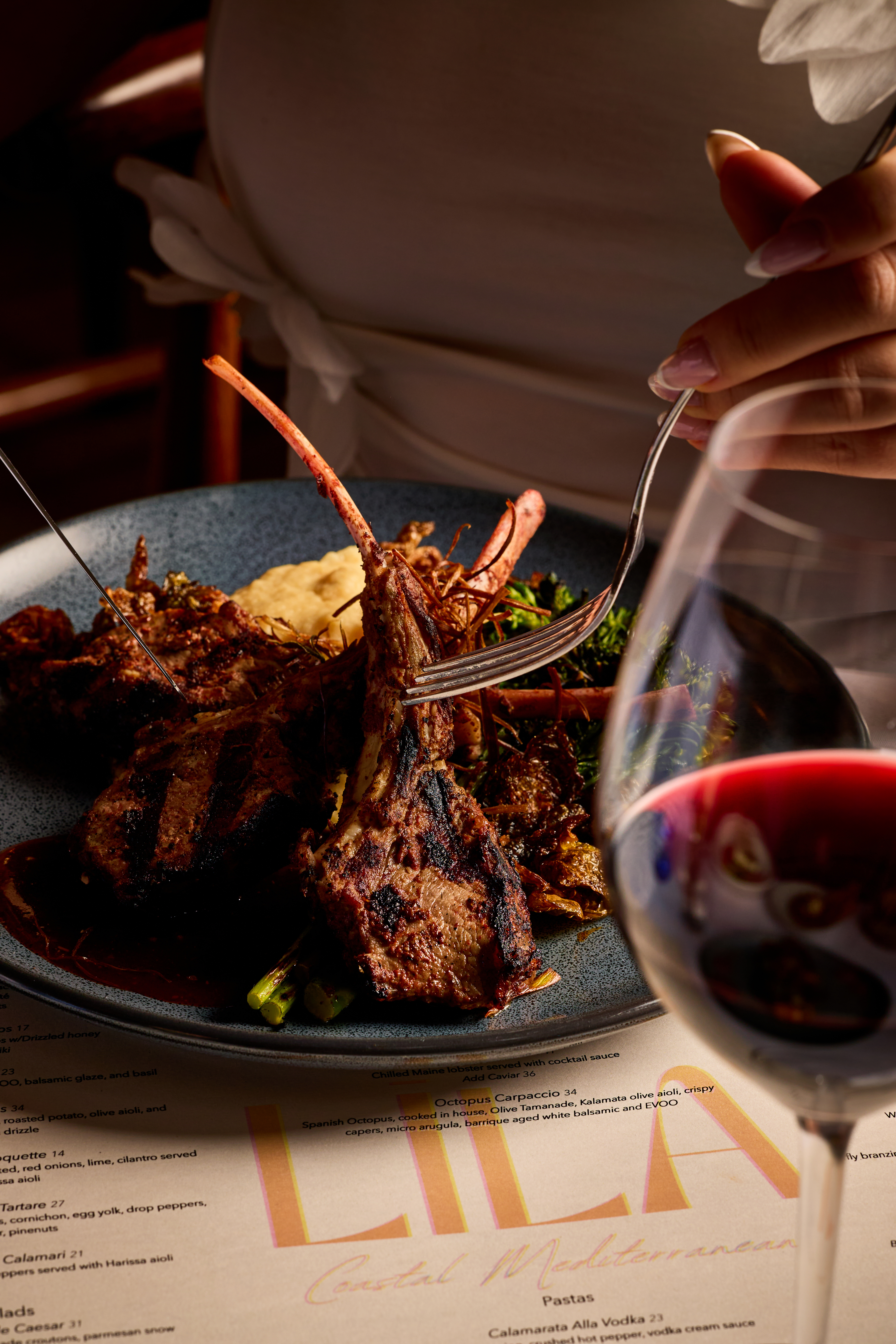 a person holding a fork over a plate of meat