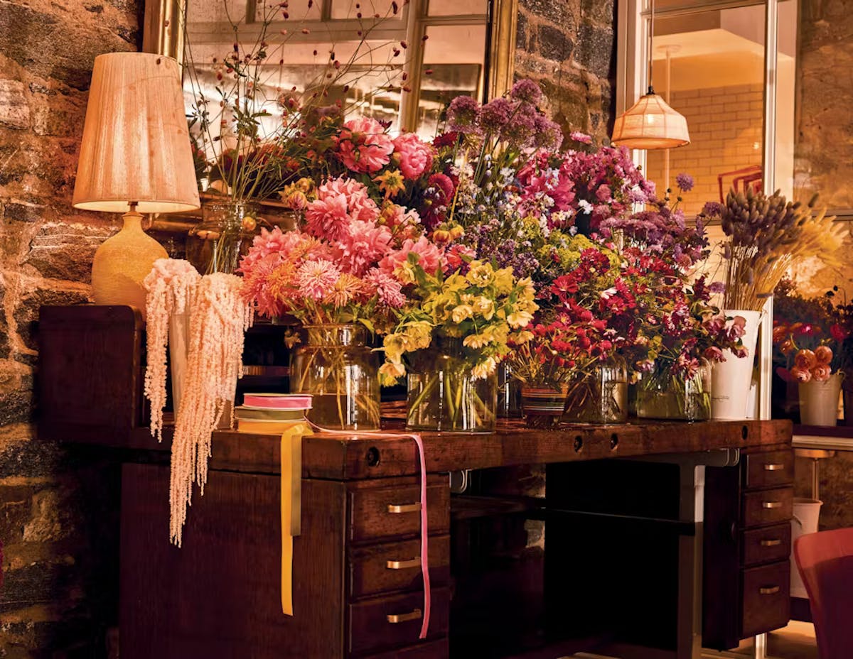 a room filled with furniture and vase of flowers on a table