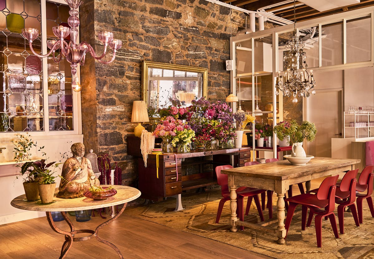 a room filled with furniture and vase of flowers on a table