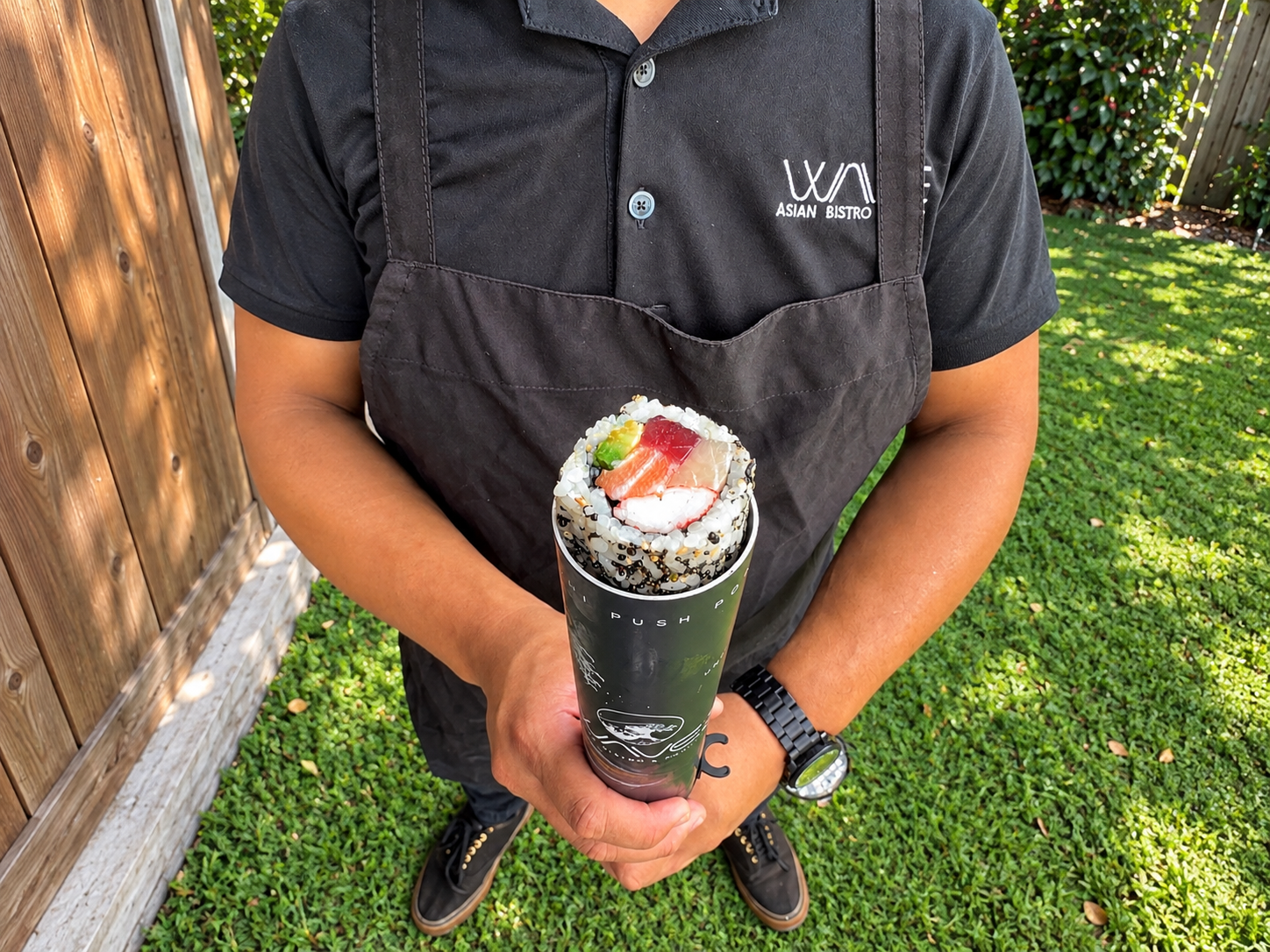 a person holding a sushi roll