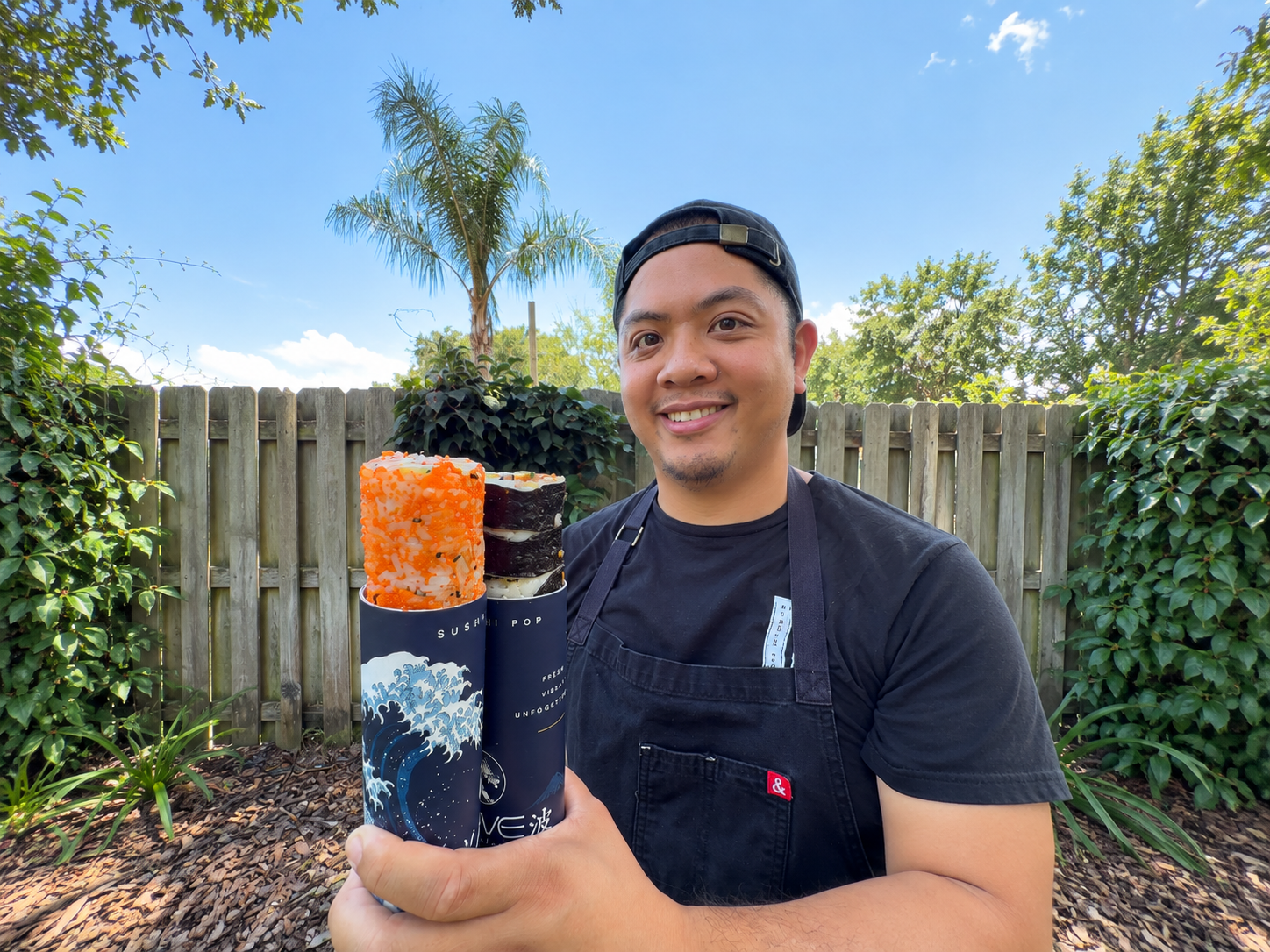 a man holding a stack of sushi rolls