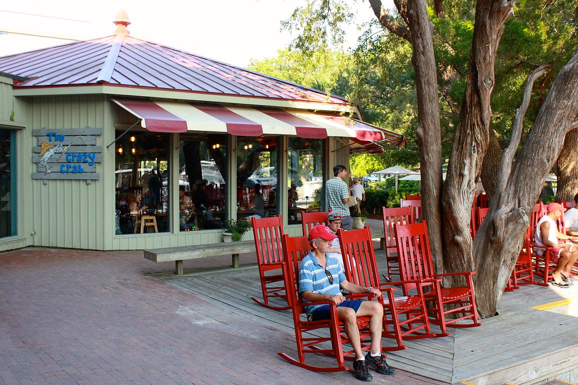 a group of people sitting on a bench in front of a house