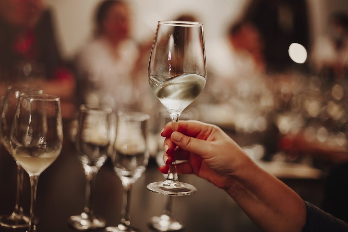 Holding glass of white wine