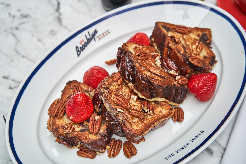 Thick-cut cinnamon, raisin and pecan French toast with pecans and berries