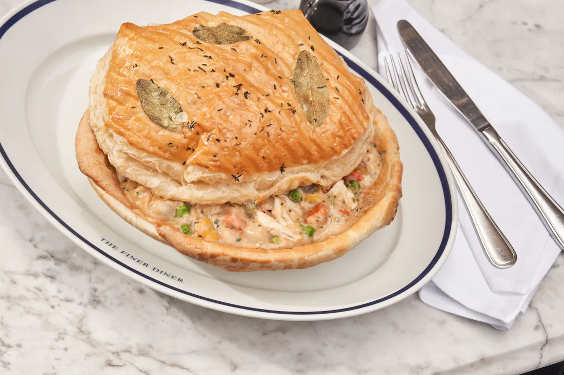 Chicken pot pie under a domed puff-pastry crust with sage