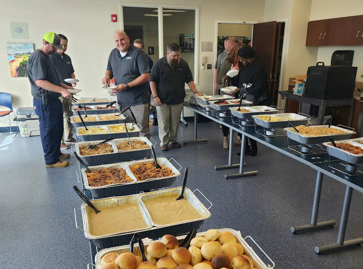 a group of people standing around a table
