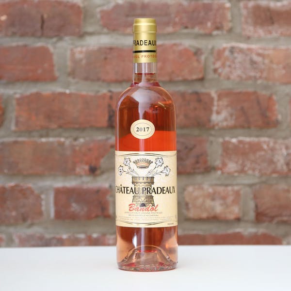 a bottle of beer next to a brick wall