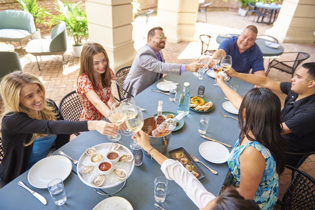 a group of people sitting at a table with food