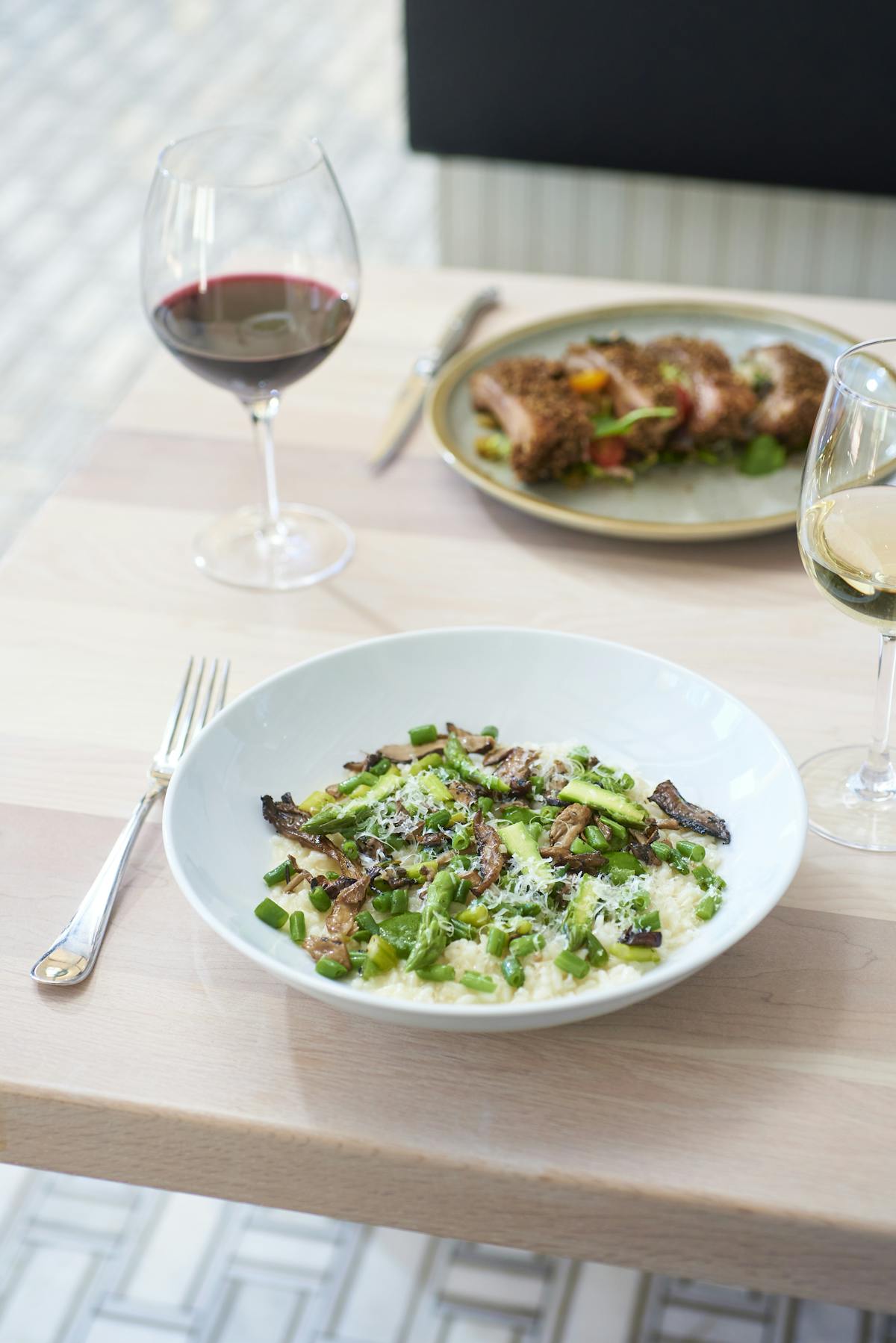 a plate of food and glasses of wine on a table