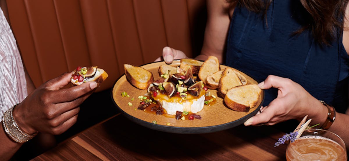 a woman sitting at a table with a plate of food