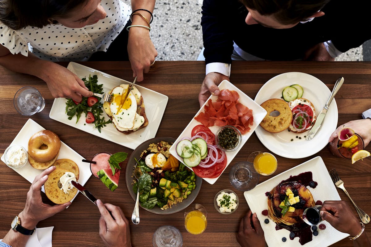 a group of people sitting at a table with a plate of food