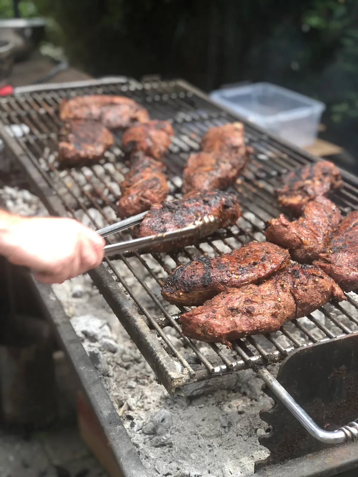 a person cooking hot dogs on a grill