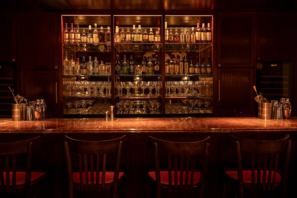 a bar with a shelf of liquor and glasses