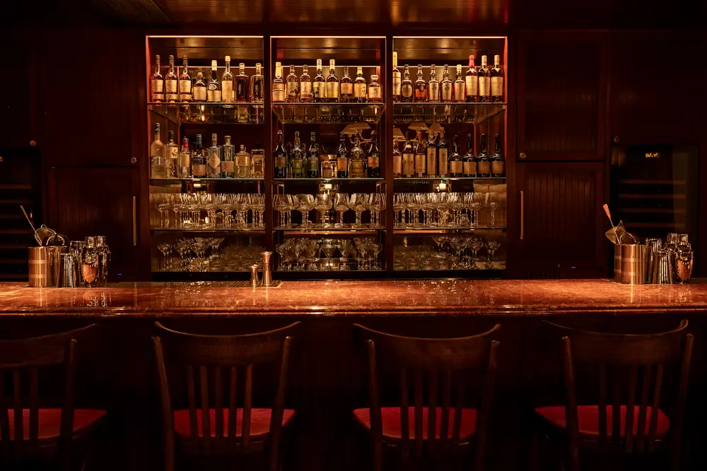 a bar with a shelf of liquor and glasses