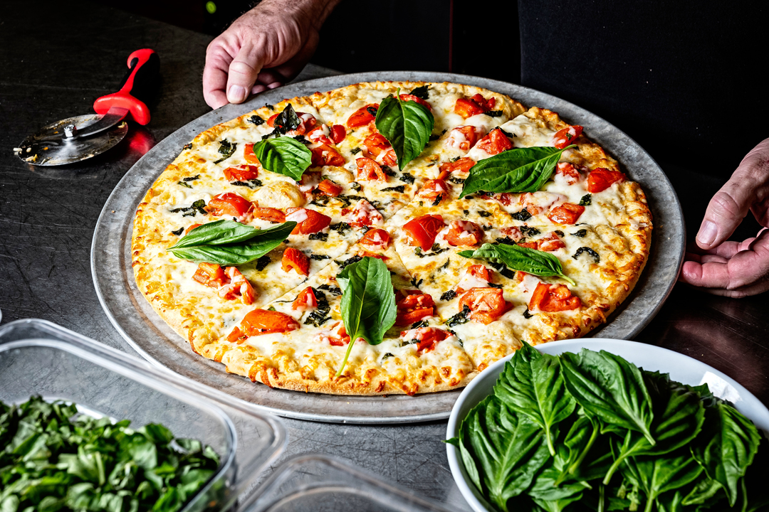 a fresh sliced pizza topped with fresh basil