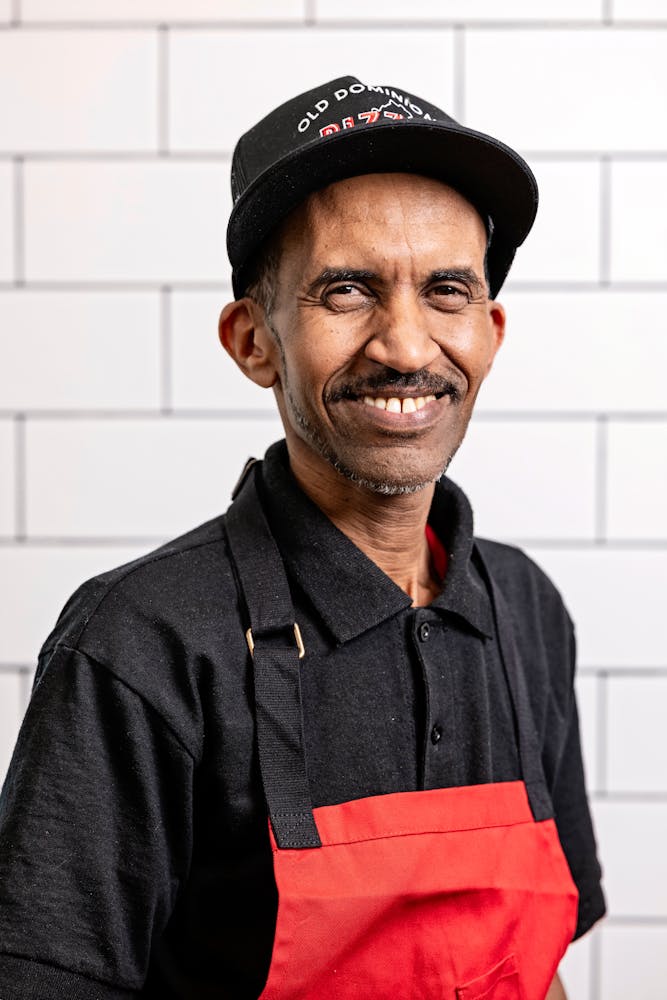 a man wearing a hat and smiling at the camera