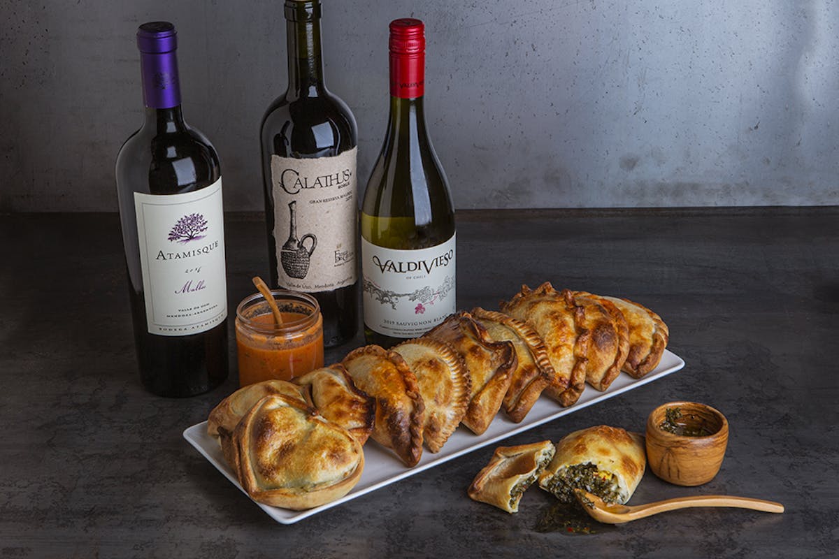 a bottle of wine sitting on top of a table full of food