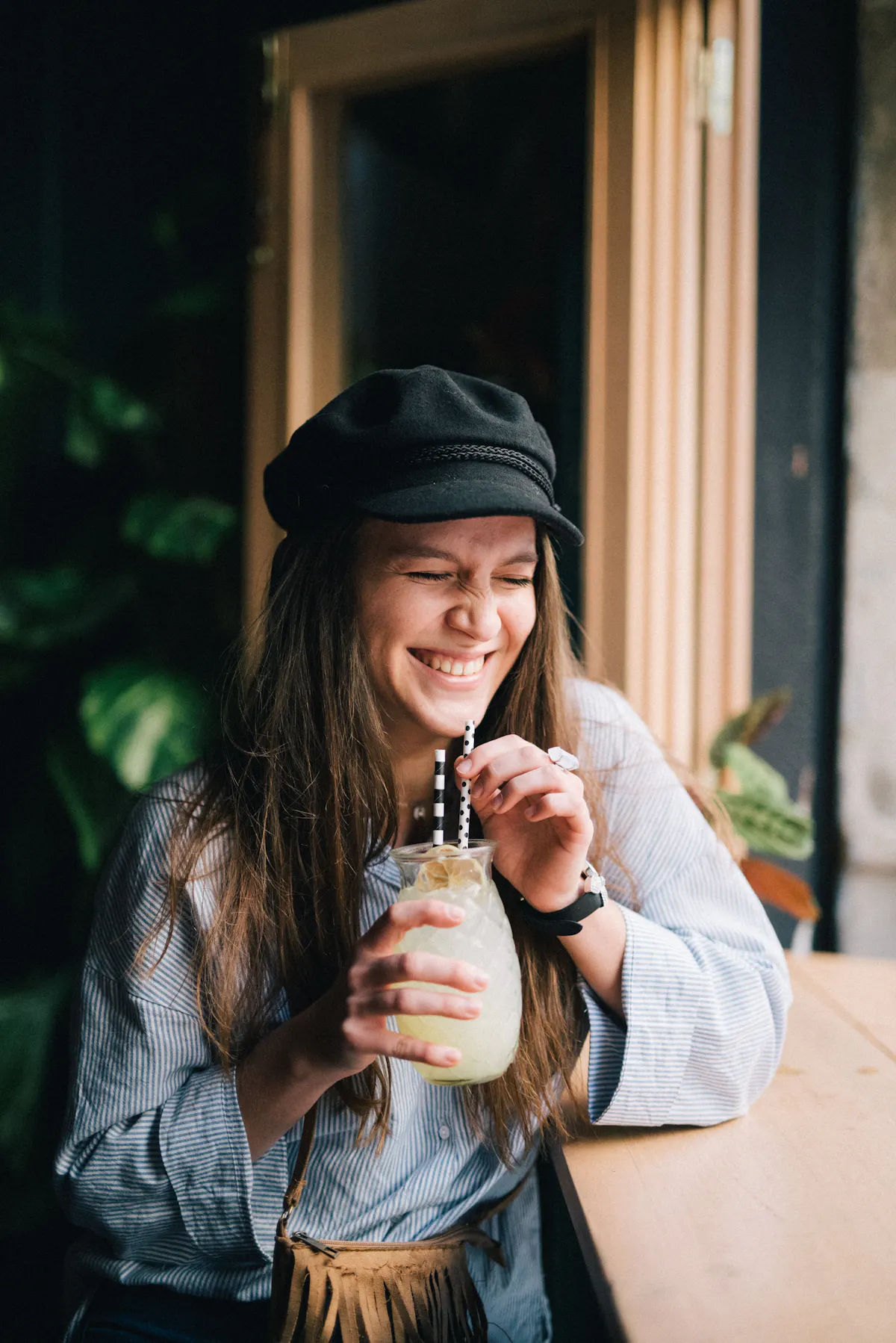 a woman wearing a hat talking on a cell phone