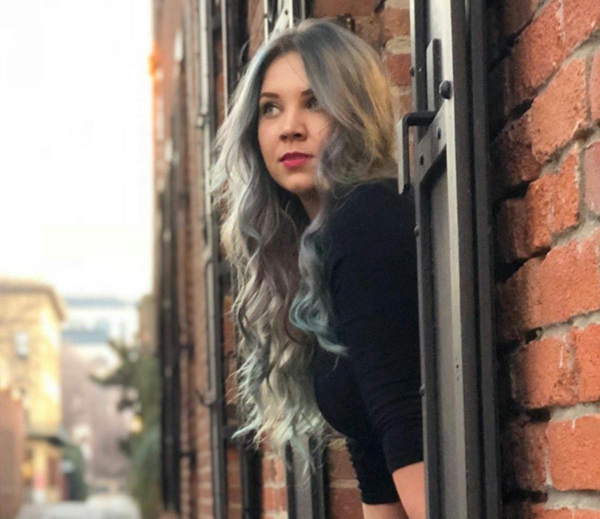 a woman standing in front of a brick building