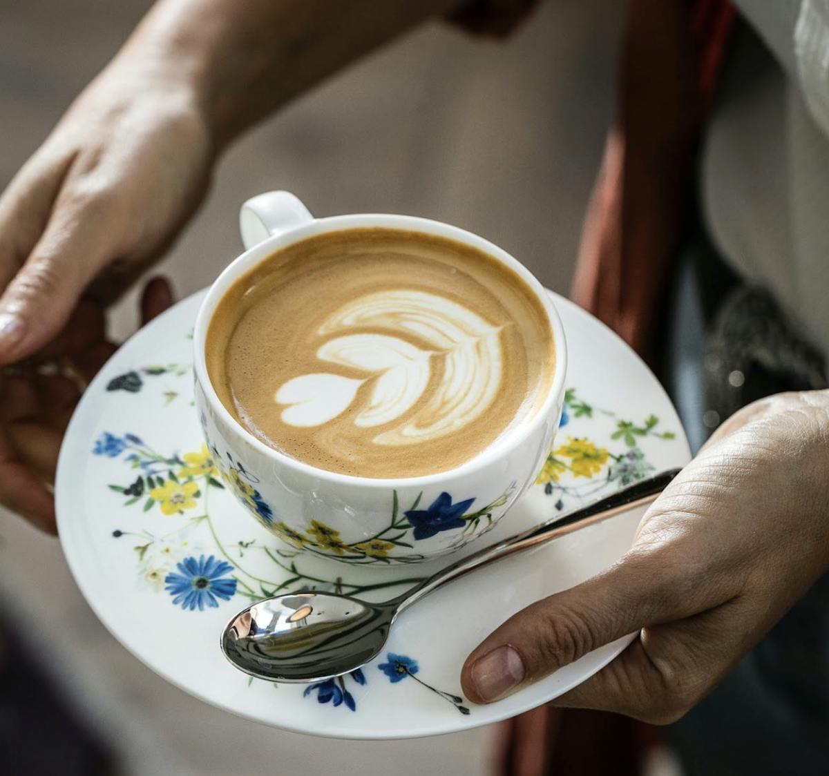 a hand holding a cup of coffee