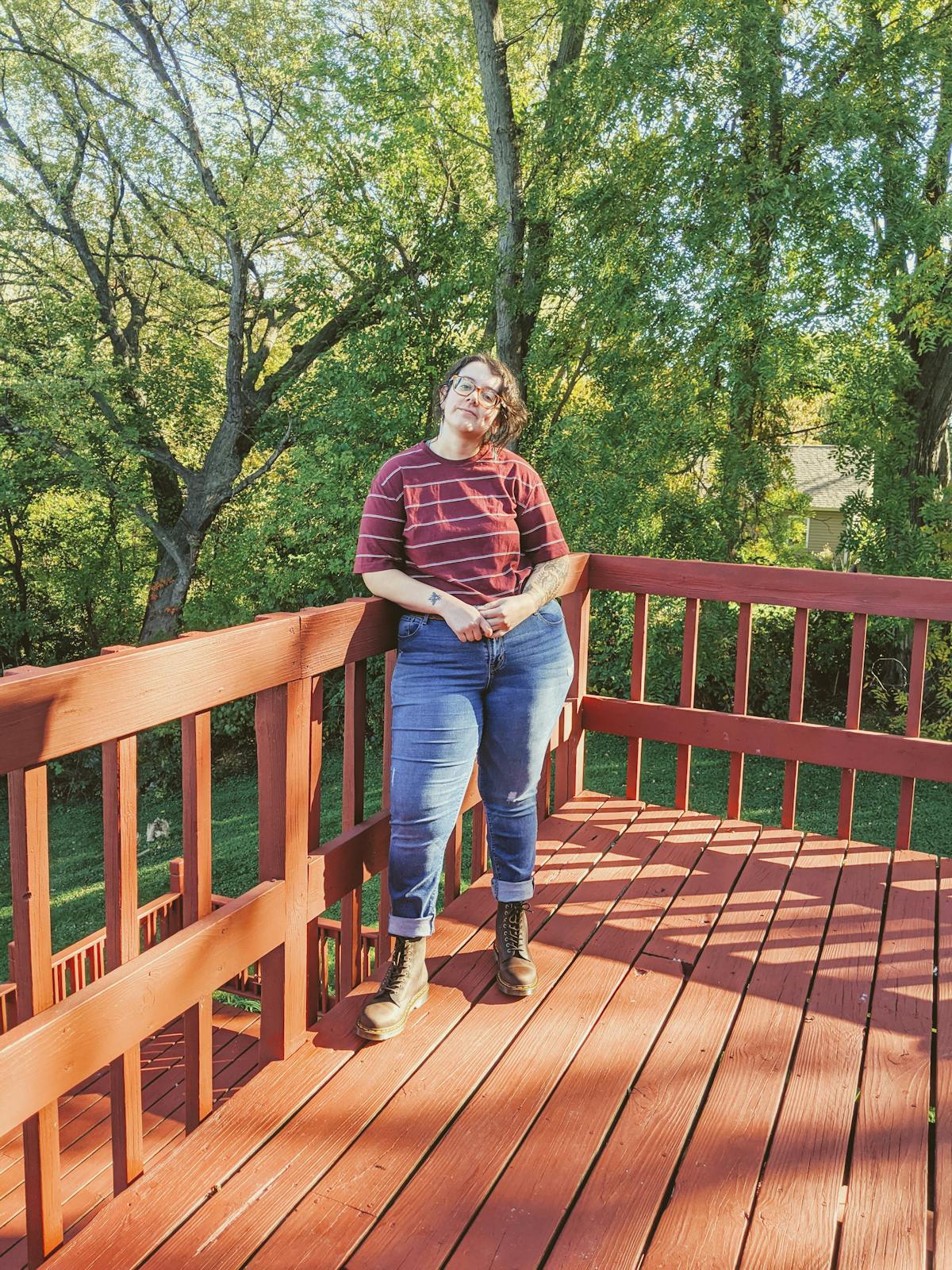 a person sitting on a bench in front of a wooden fence