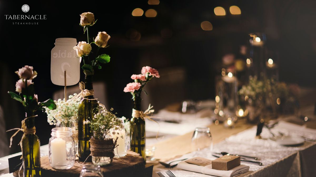 Floral centerpiece with candles and wine bottles at a kosher rehearsal dinner table in Manhattan at Tabernacle Steakhouse