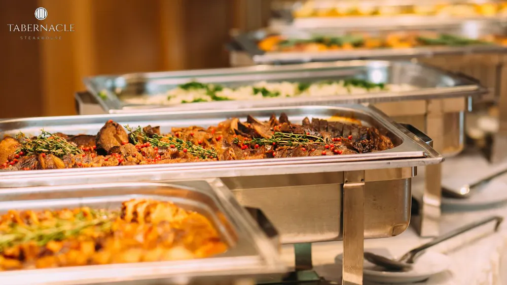 Kosher catering buffet spread with braised meat and sides at a Manhattan private dining event at Tabernacle Steakhouse