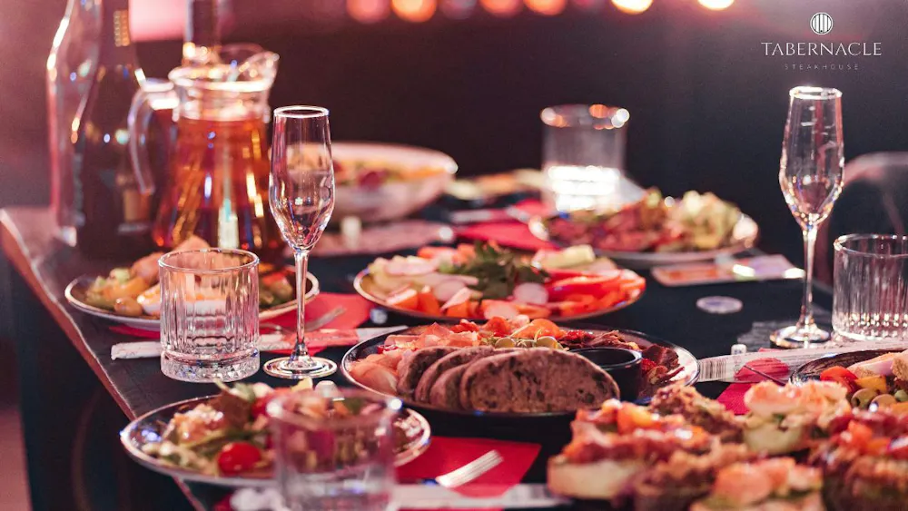 a table with plates of food and glasses