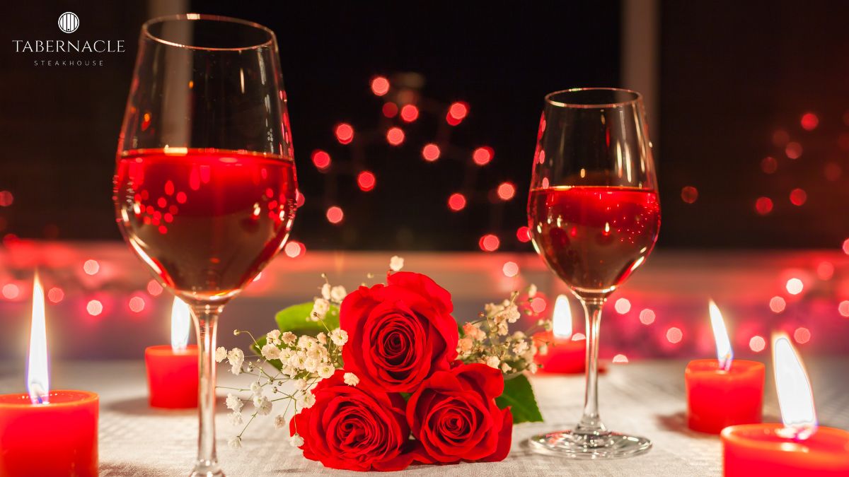 Two glasses of kosher wine with red roses and candles at Tabernacle Steakhouse for a romantic NYC anniversary dinner