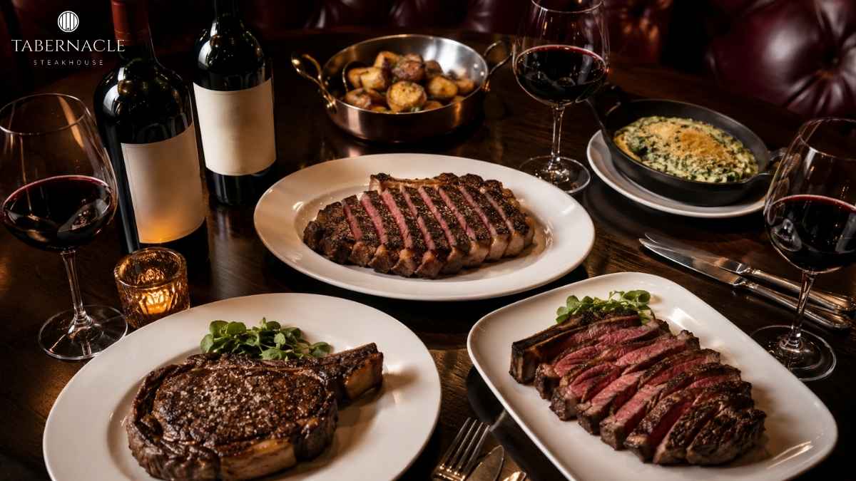 sliced-steak-platters-with-red-wine-and-side-dishes-on-table