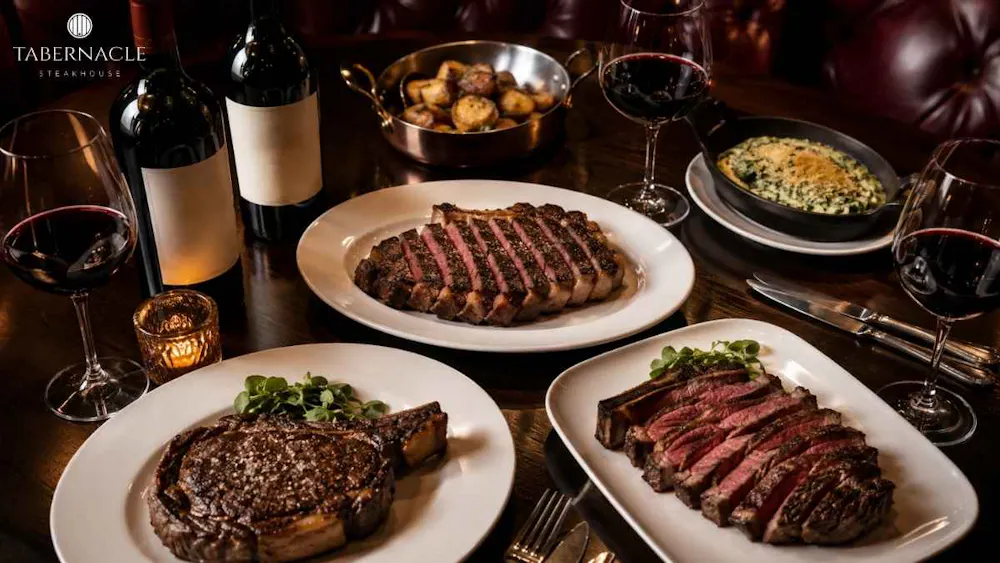 sliced-steak-platters-with-red-wine-and-side-dishes-on-table