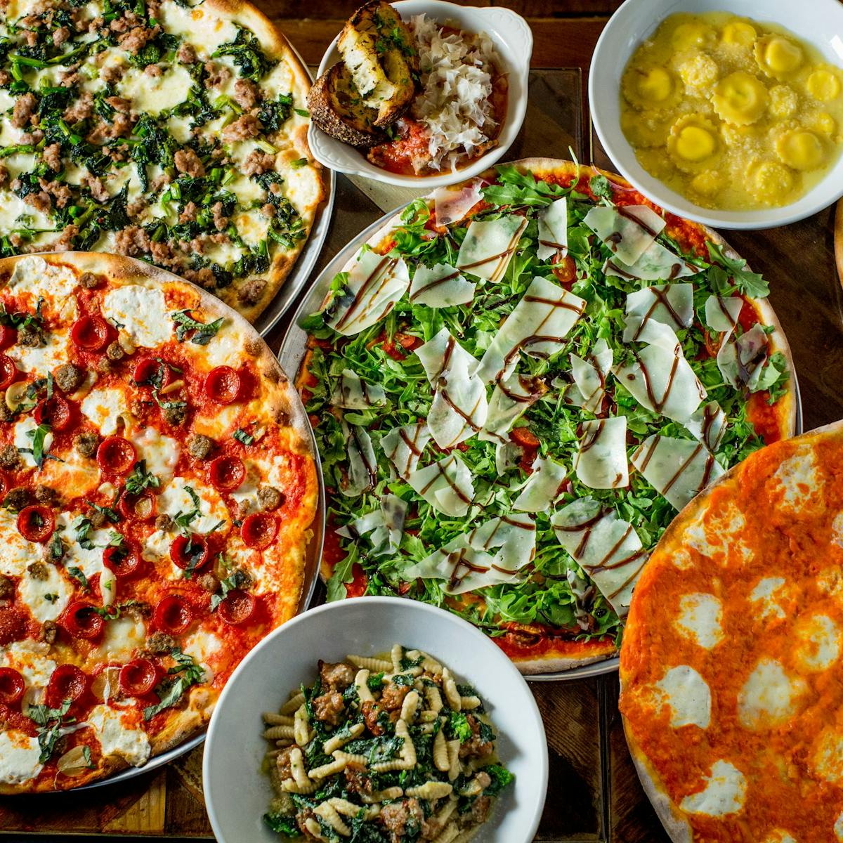 a pizza with many different types of food on a table