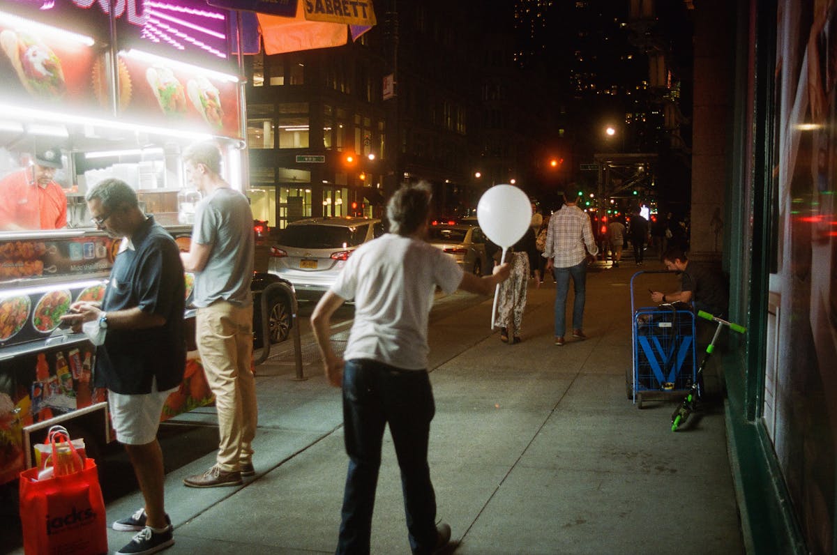 a group of people standing on a sidewalk