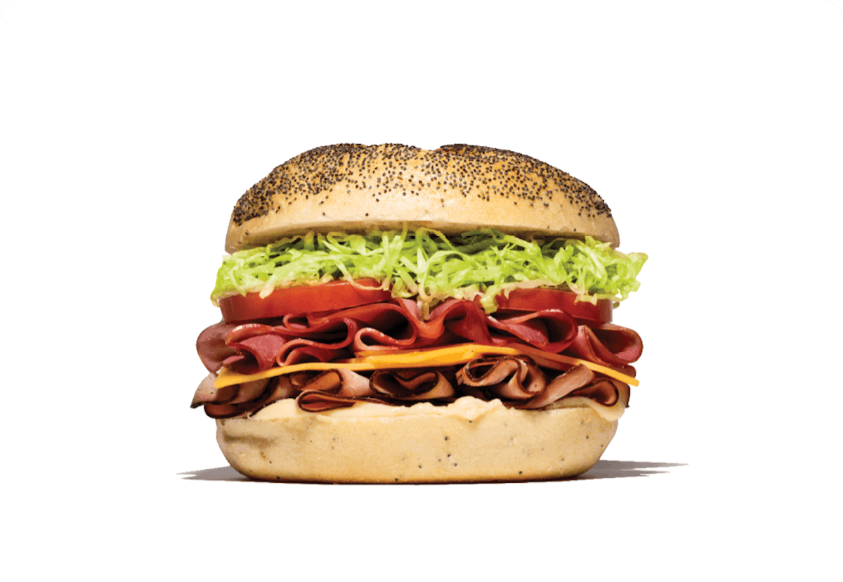 close up of a ham and cheese sandwich with lettuce on a kaiser roll