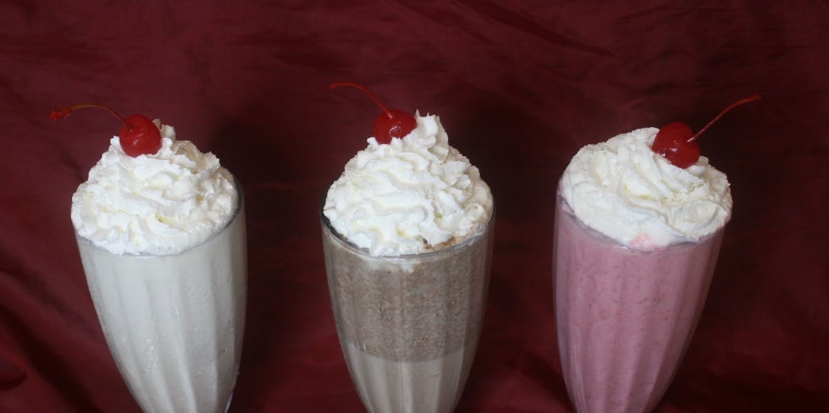 milkshakes with whip cream and a cherry
