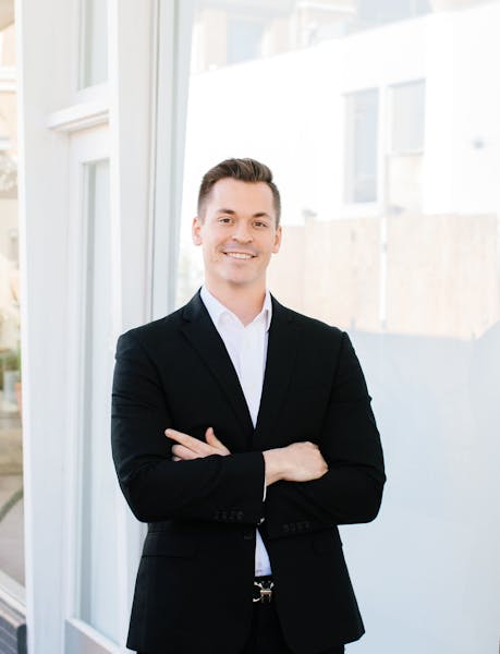 a person in a suit standing in front of a window