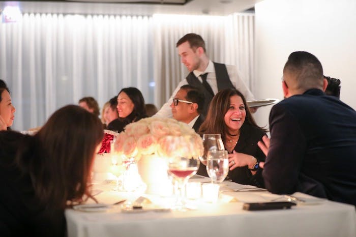 a group of people sitting at a table with wine glasses