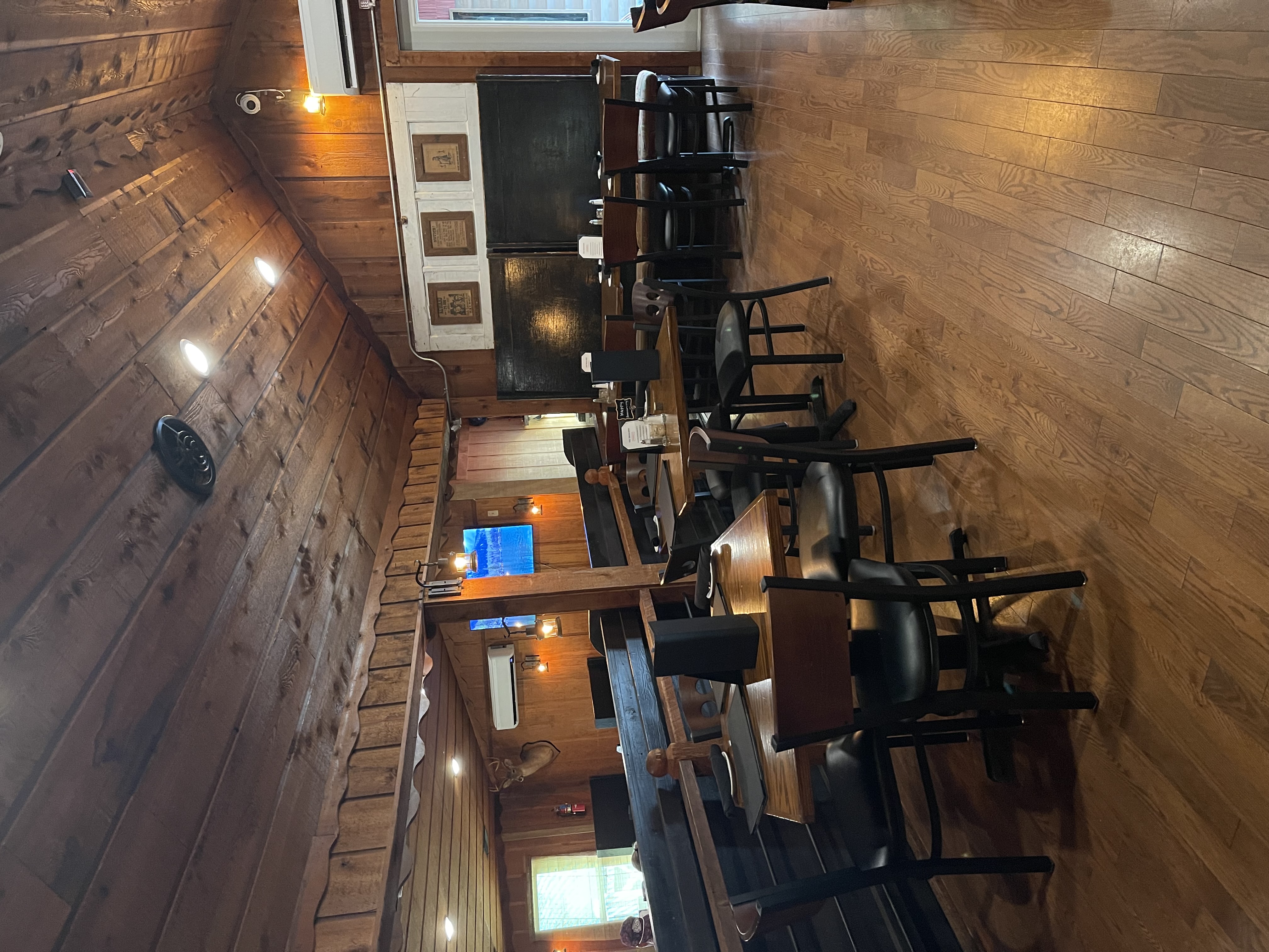 a room with wooden walls and tables and chairs